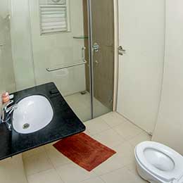 Wash Room: Spotlessly clean sanitary ware, spotlessly clean white tiles and a shower enclosure at Concord Gachibowli Serviced Apartment